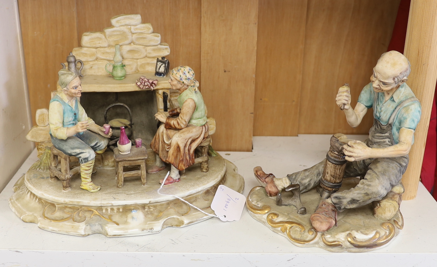 A Capo di Monte figure group of peasants by a fire and a cobbler